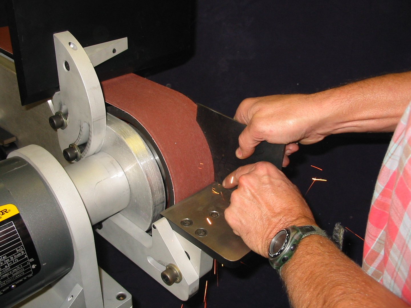 Grinding metal with sparks on Shannon Precision belt sander